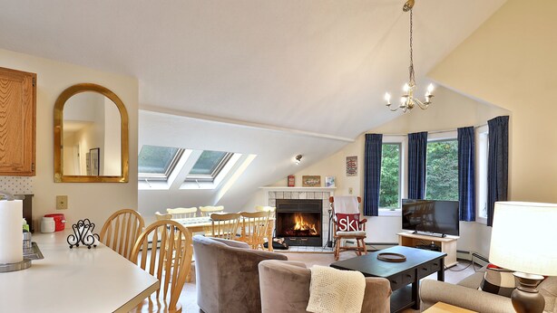 A spacious living area with a fireplace, comfortable seating, and a television.