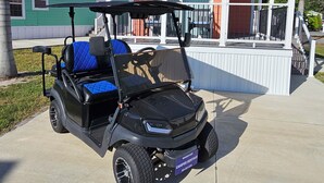 Golfiauton voi nähdä pysäköitynä talon edessä, jossa on kuisti.