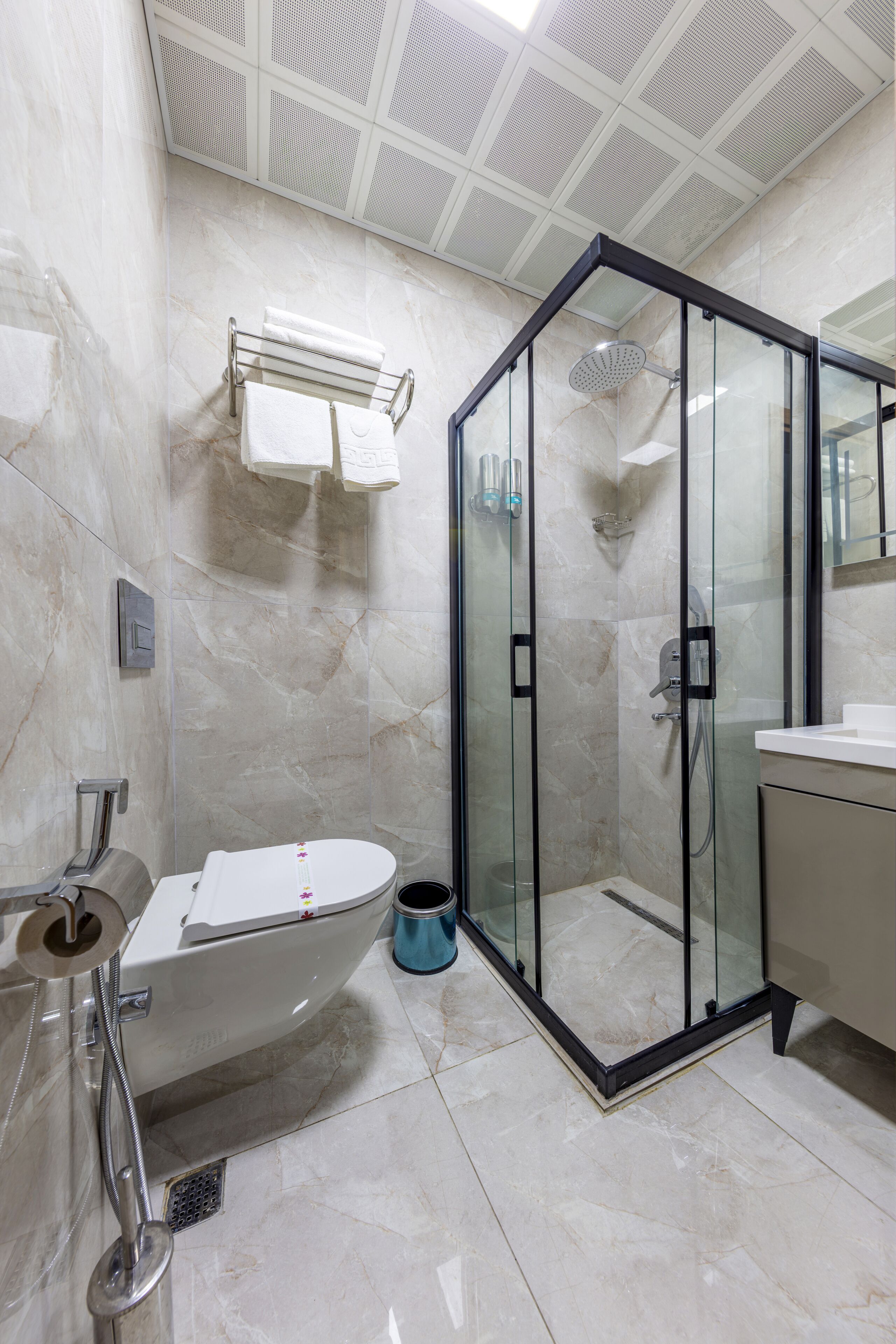 A bathroom with a glass-enclosed shower, a bathtub, and a toilet.