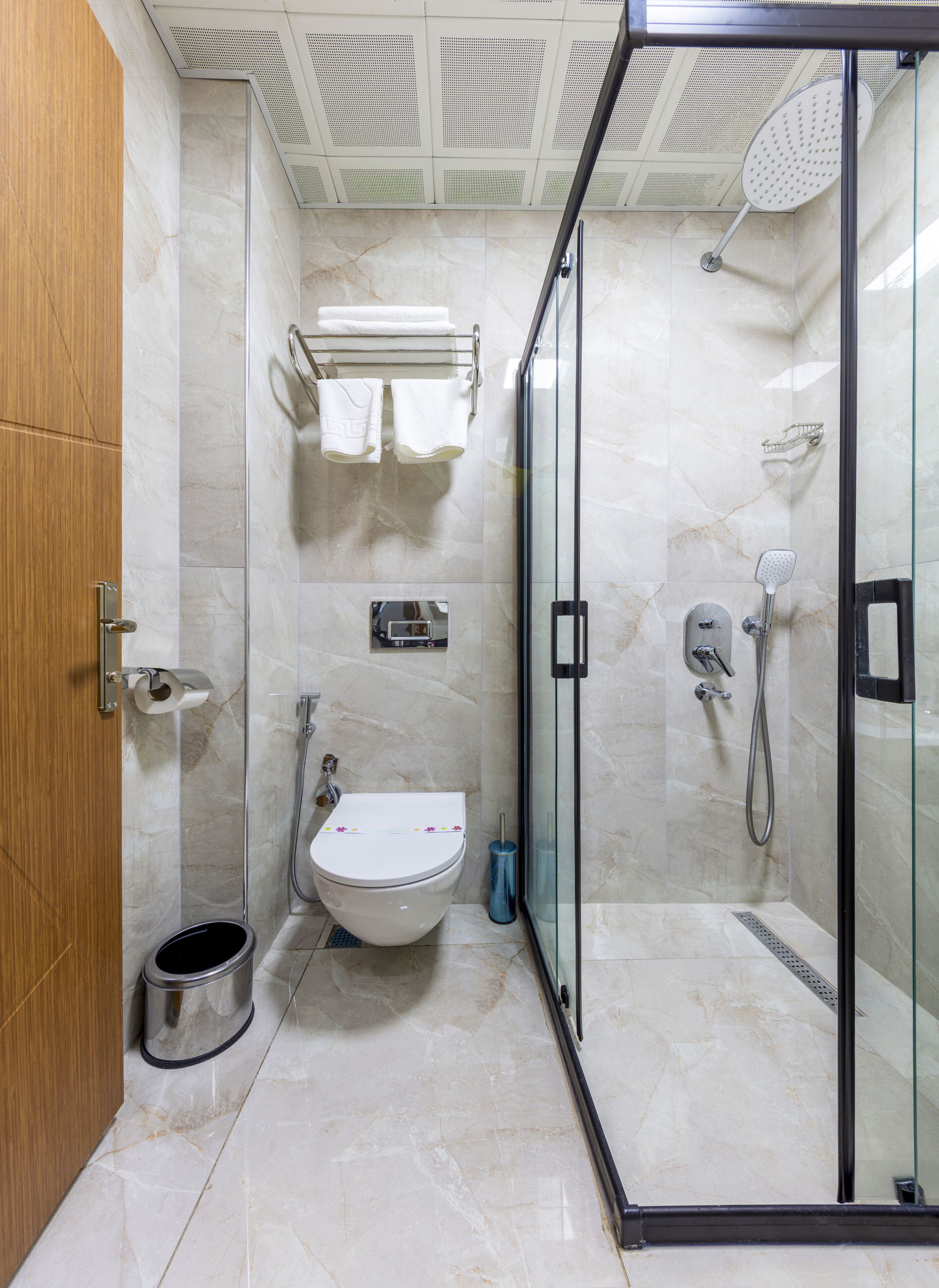 Un baño moderno con ducha de vidrio, inodoro y lavamanos.