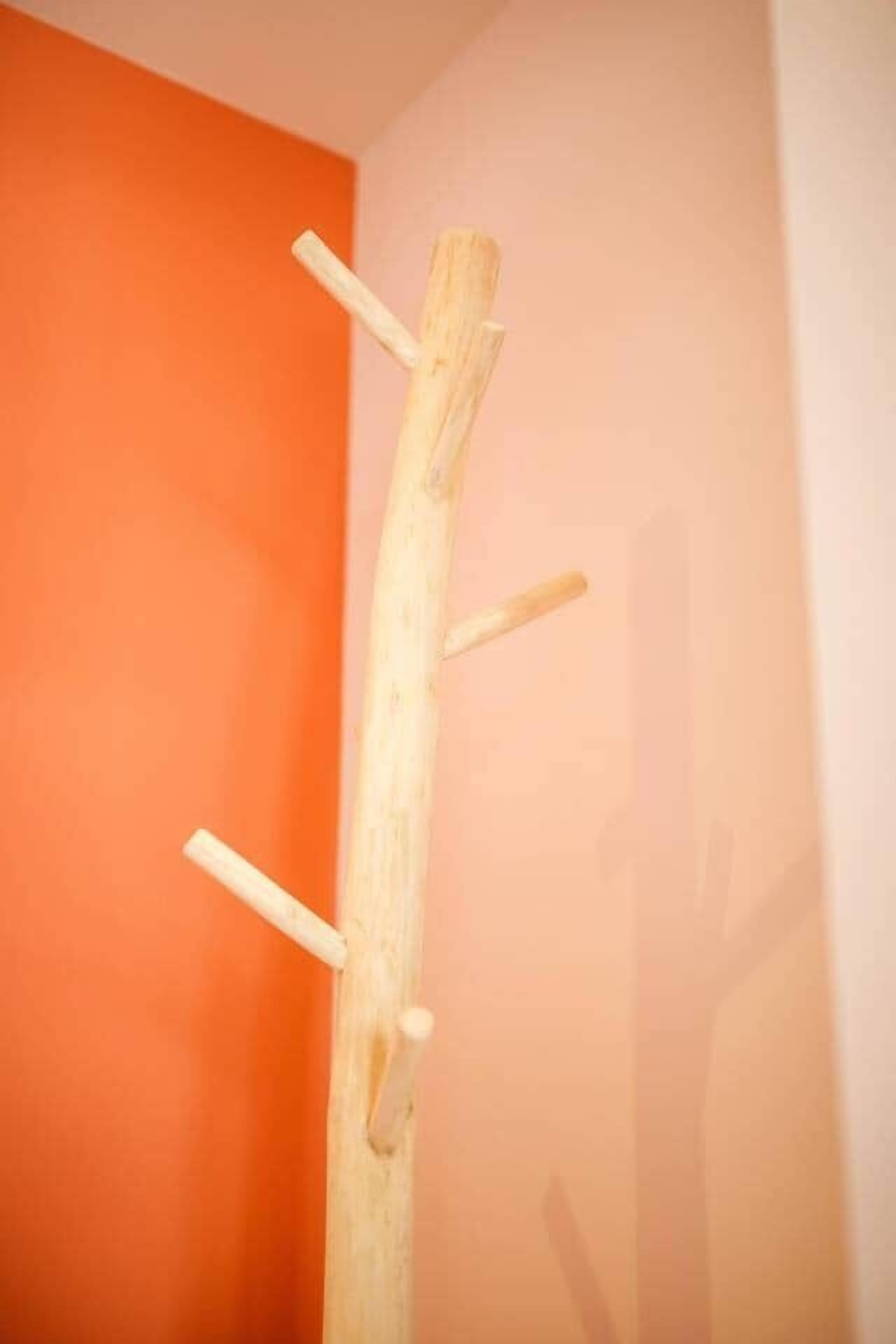 Una struttura in legno con tre barre orizzontali addossata a un muro.