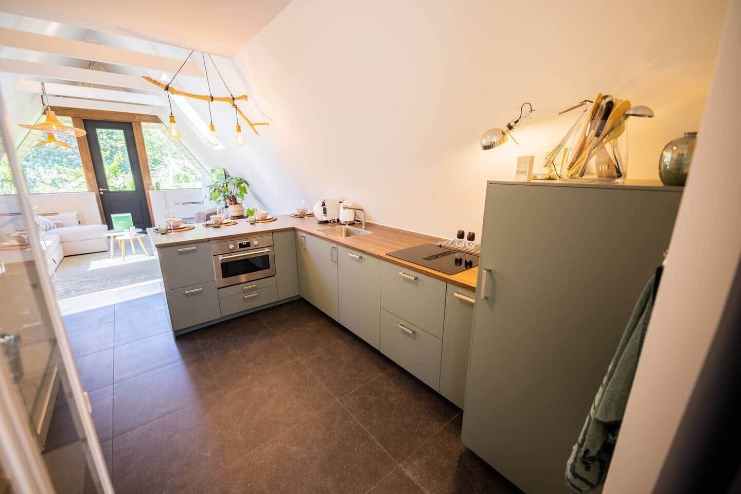Una cocina moderna con horno integrado, un lavamanos y una encimera con cafetera.