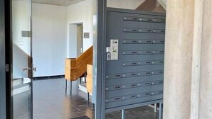 A modern interior with a glass door entrance, a staircase, and a wall-mounted mail slot. - Fantastic Studio with free private car parking ('s-Hertogenbosch)
