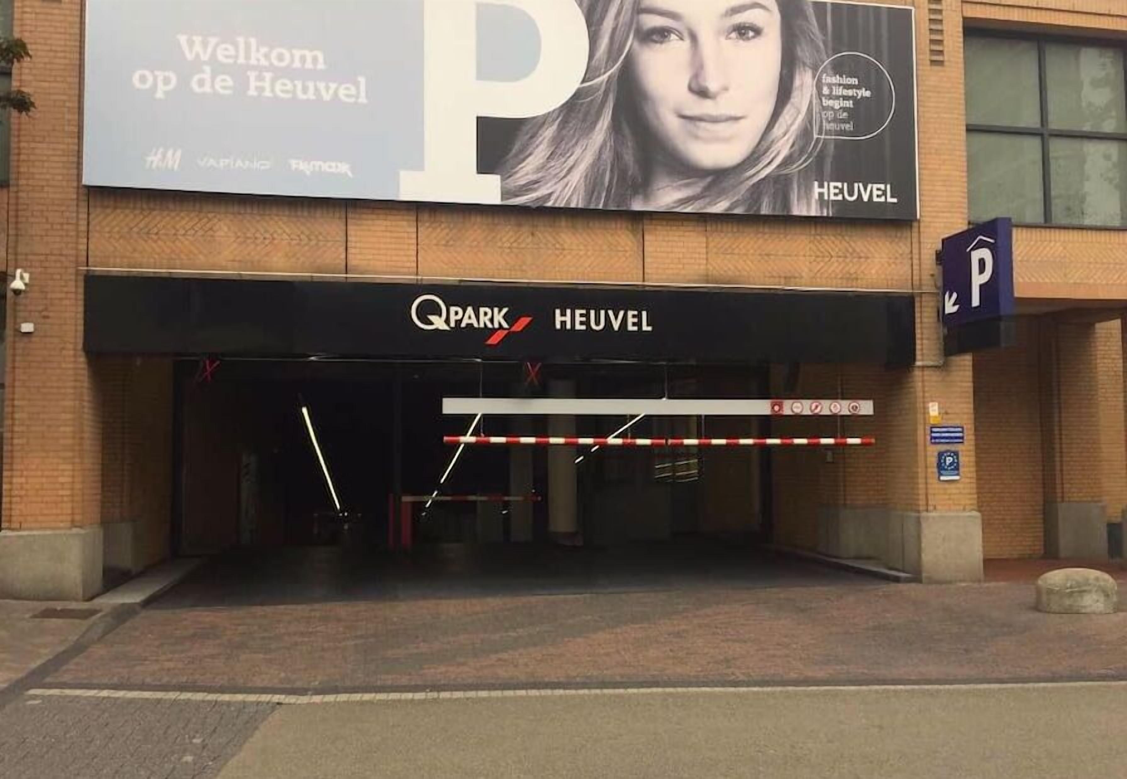 Een winkelentree met een groot reclamebord voor een modehuis.