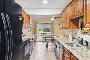 Enjoy meals in the kitchen with a sink, dining area, and sliding glass doors offering a view of the outdoors.