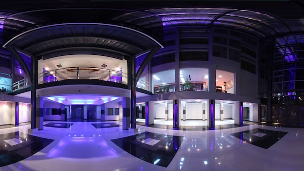 Un hôtel moderne avec un intérieur contemporain, de nombreux étages, des rampes de verre et un atrium central.