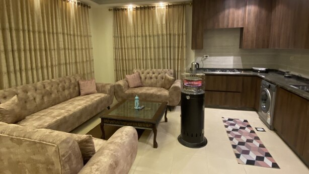 Uma sala de estar com um sofá seccional, uma mesa de centro e uma lareira.