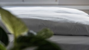 A bed with white bedding in a room with a window. - Hotel Goldener Stern – Self check-in (Lucerne)