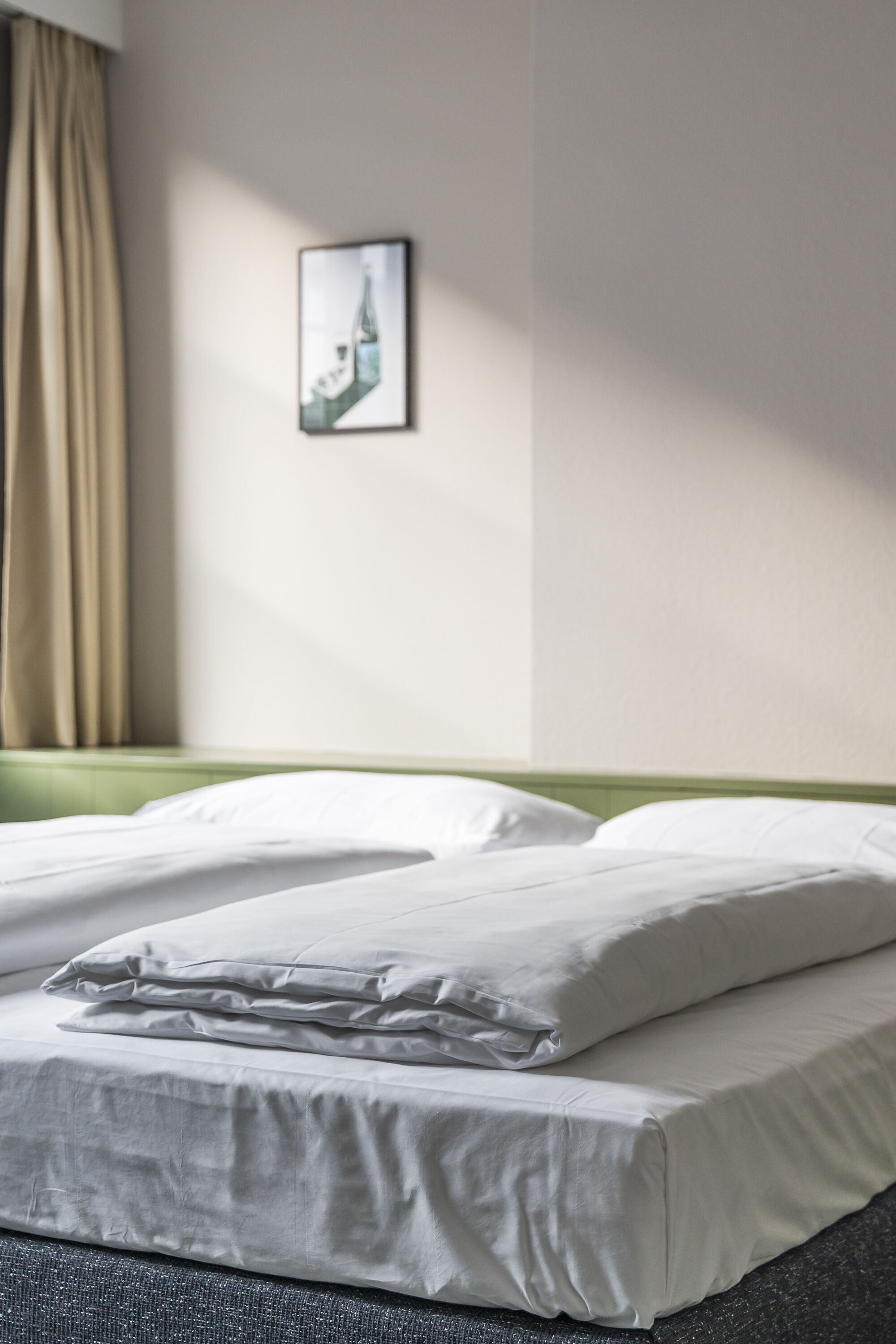 Una cama bien hecha con sábanas blancas en una habitación de hotel.