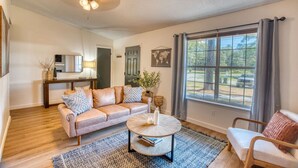 A living room with a sofa, coffee table, and a view of the outdoors.