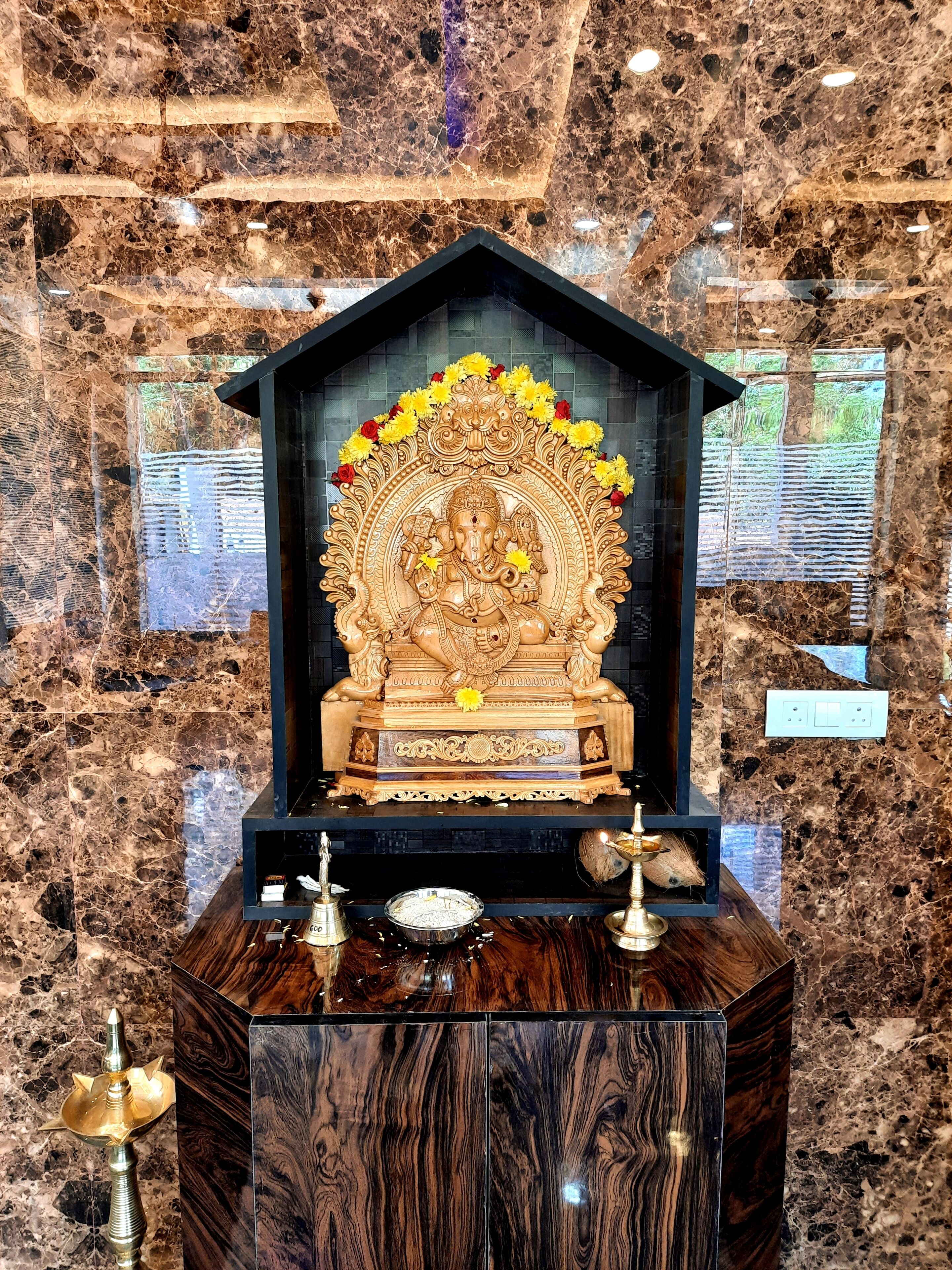 A marble wall with a statue of a deity in a niche.