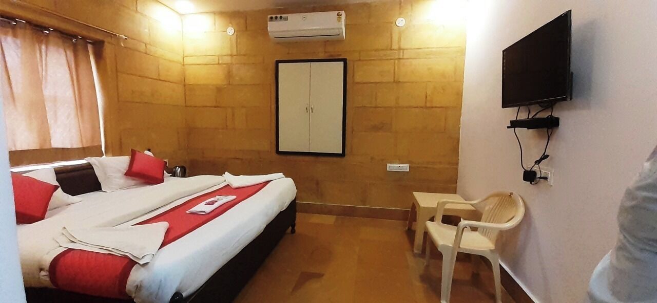 A hotel room with a bed, a wardrobe, a television, and a small table.