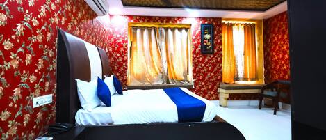 Une chambre d’hôtel équipée d’un lit, d’un bureau, d’une chaise et d’un ventilateur de plafond.
