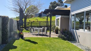 A backyard with a pergola, outdoor seating, and a grassy lawn. - Convenient town house close to town and a great location to explore the region (Richmond)
