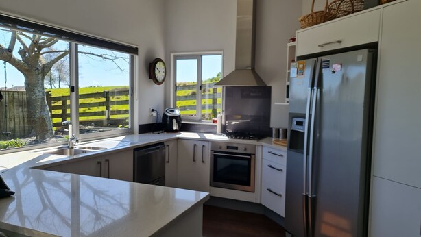 A modern kitchen with a large island, stainless steel appliances, and a view of a green landscape through the window. - Convenient town house close to town and a great location to explore the region (Richmond)
