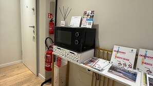 A reception desk with informational brochures, a fire extinguisher, and a door with a 'No Entry' sign. - Malvezzi24 Boutique Rooms (Desenzano del Garda)