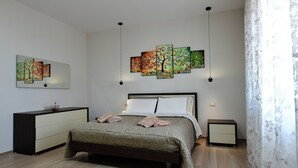 A bedroom with a bed, dresser, nightstand, and wall art. - Villa with pool for 8 guests with 3 bedrooms (Puglia)
