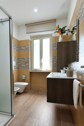 Une salle de bain avec des toilettes, un lavabo, un miroir et une fenêtre.