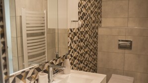 A bathroom with a white sink, a mirror, a towel rack, and a toilet. - Penzion Moon (Ostrava)