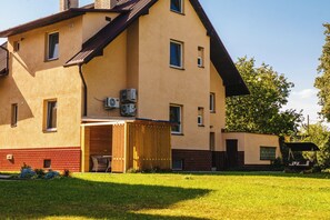 Un edificio de dos pisos con techo plano, unidades de aire acondicionado y un área de estar al aire libre techada.