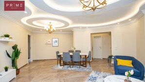 A spacious living area with a dining table, chairs, a sofa, and a coffee table. - Prime Select Marvel New Cairo (New Cairo)