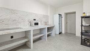 A modern kitchen with marble backsplash, built-in microwave, and stainless steel appliances. - Hostel na Šalamouně (Ostrava)