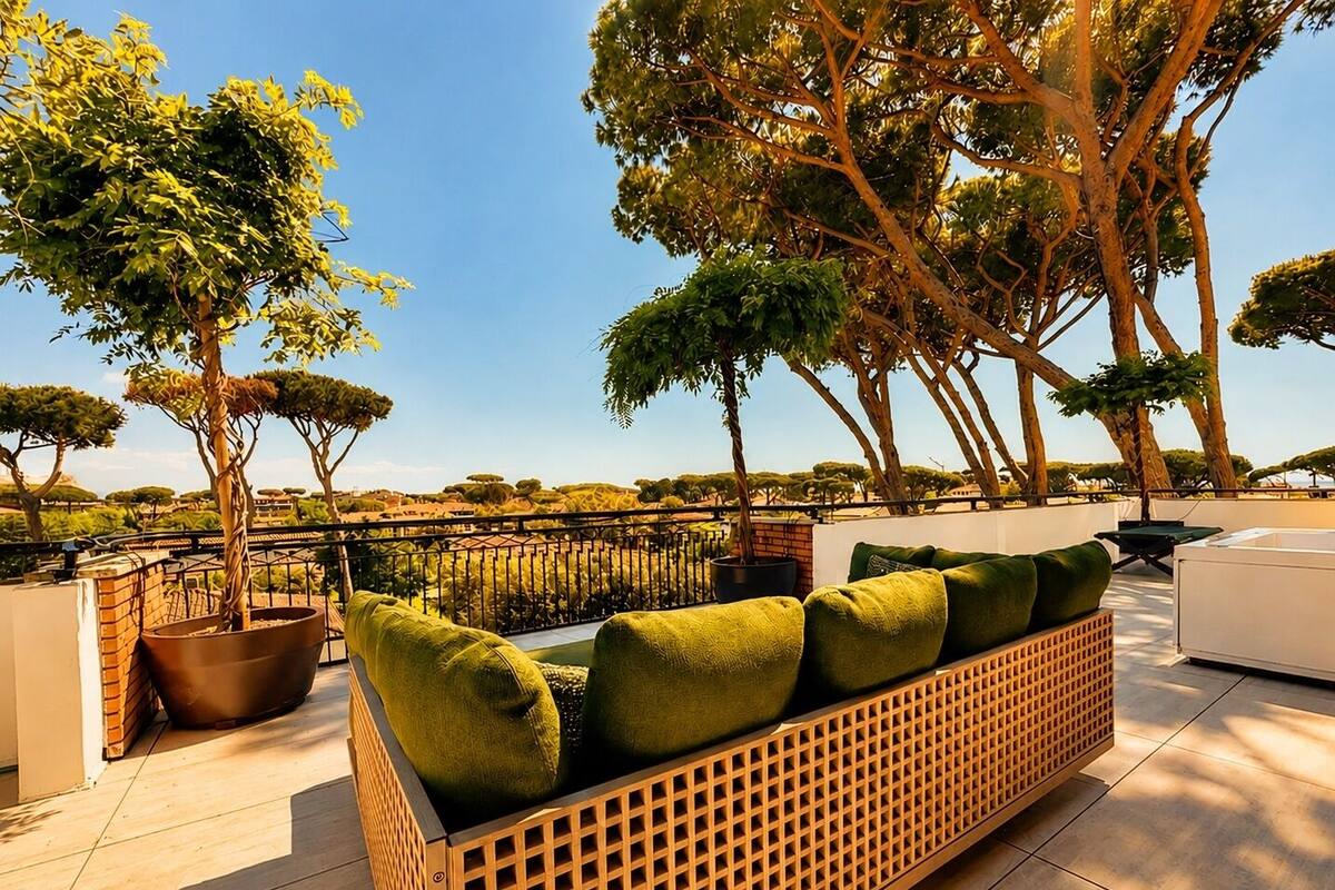An outdoor seating area with a wooden lattice sofa, green cushions, and potted plants.