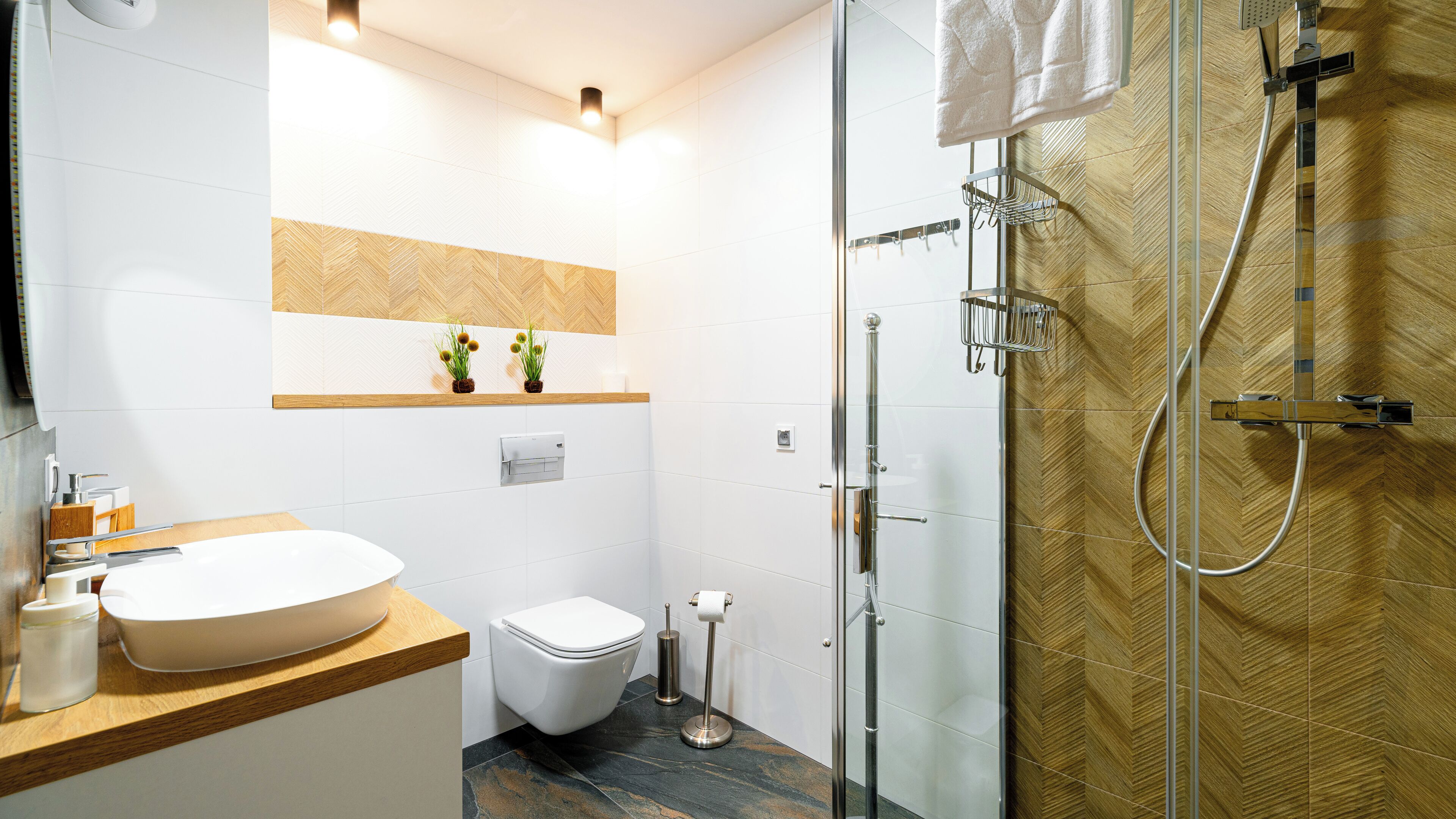 Un bagno moderno con doccia vetrata, lavandino bianco e servizi igienici.