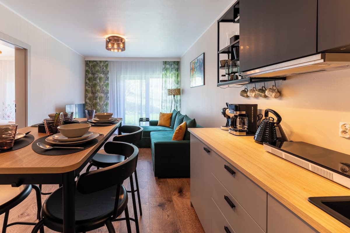 Een moderne keuken met een eethoek, houten kastjes en een koffieapparaat.