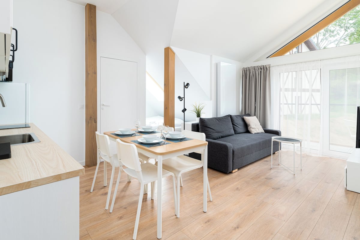 Een moderne, open woonruimte met keuken, eethoek en zithoek.