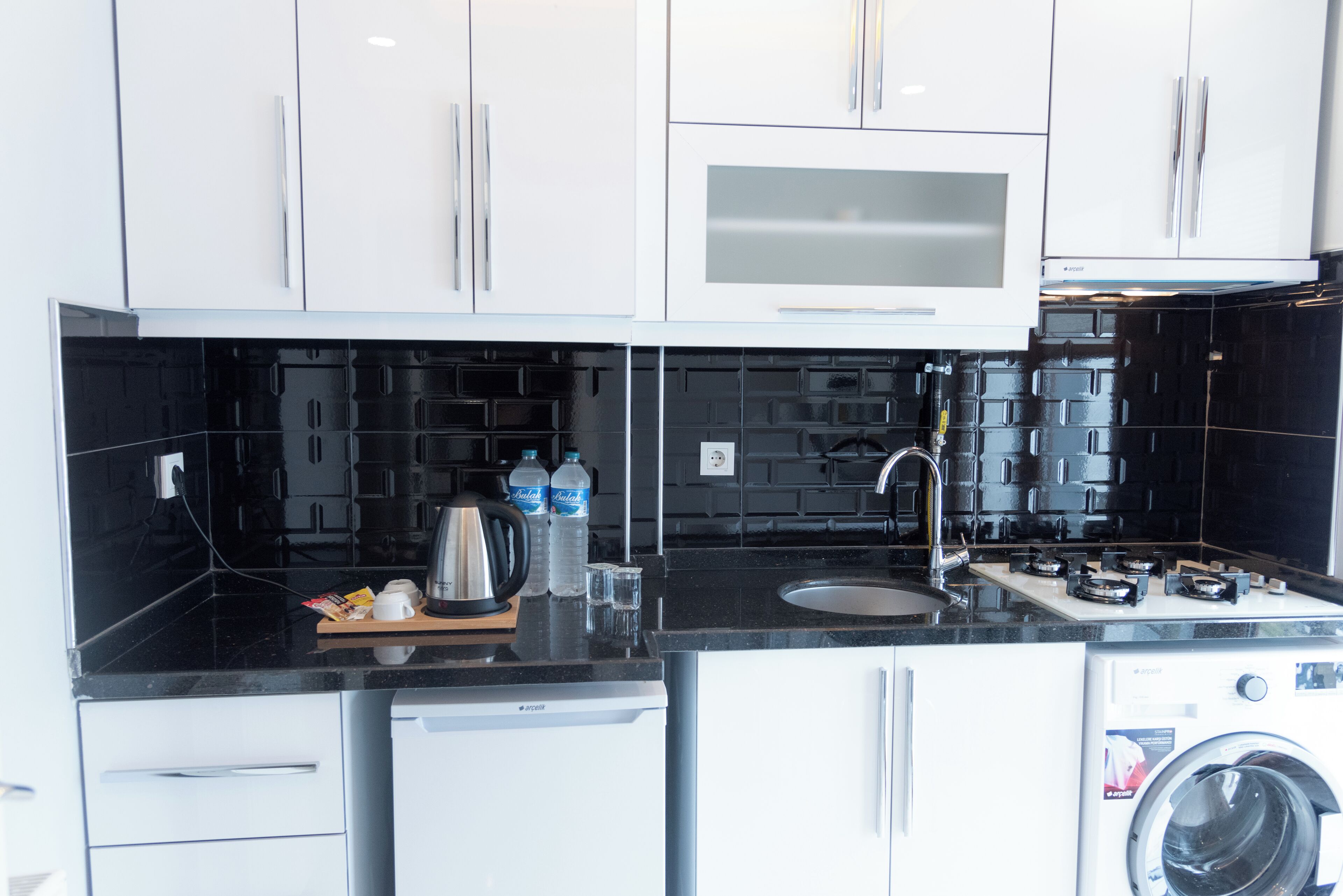 Standaard suite | Privékeuken | Een mini-koelkast, een kookplaat, kookgerei, borden en bestek