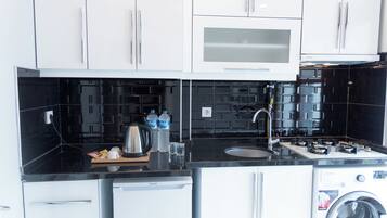 Standaard suite | Privékeuken | Een mini-koelkast, een kookplaat, kookgerei, borden en bestek