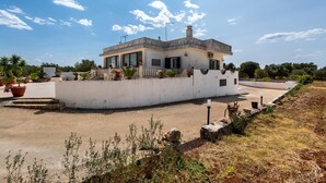 A single-story house with a flat roof, large windows, and a paved driveway. - 3634 Villa Dolce - App1 by Barbarhouse (Ostuni)