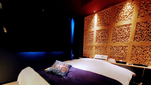 A room with a bed, a bedside table, and a decorative wall panel. - HOTEL FOURSEASON - Adults Only - (Takaoka)