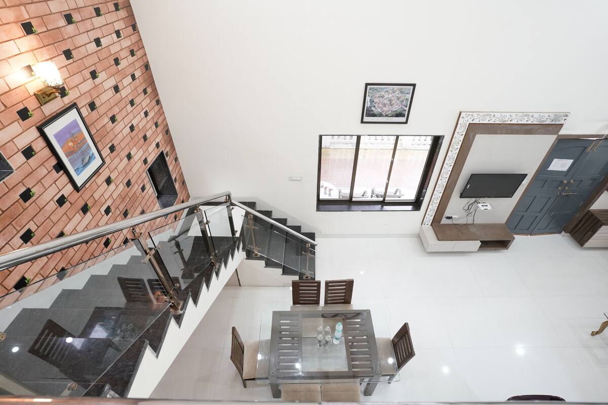 A modern interior with a staircase, a dining area, and a view of the outside.