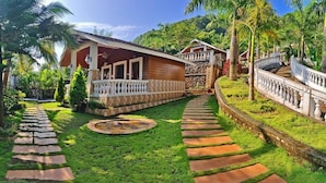 A resort with a paved pathway leading to a wooden building with a balcony. - Siddhant Hill Resort (Murud)