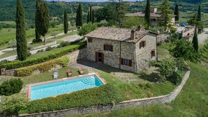 A stone villa with a swimming pool, surrounded by lush greenery and vineyards. - Fienile al Corno, Radda in Chianti, Siena and Chianti (Radda in Chianti)