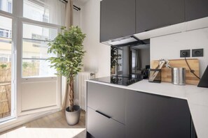 Une cuisine moderne avec une grande fenêtre, une plante en pot et un four encastré.