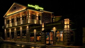 A two-story building with a balcony and a neon sign. - VinoOdor Wine Boutique Hotel in Telavi (Telavi)