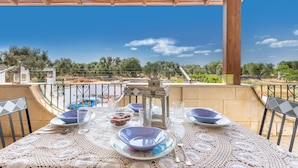 A table set for dining on a balcony with a view of the countryside. - 3635 Villa Dolce - App 2 by Barbarhouse (Ostuni)