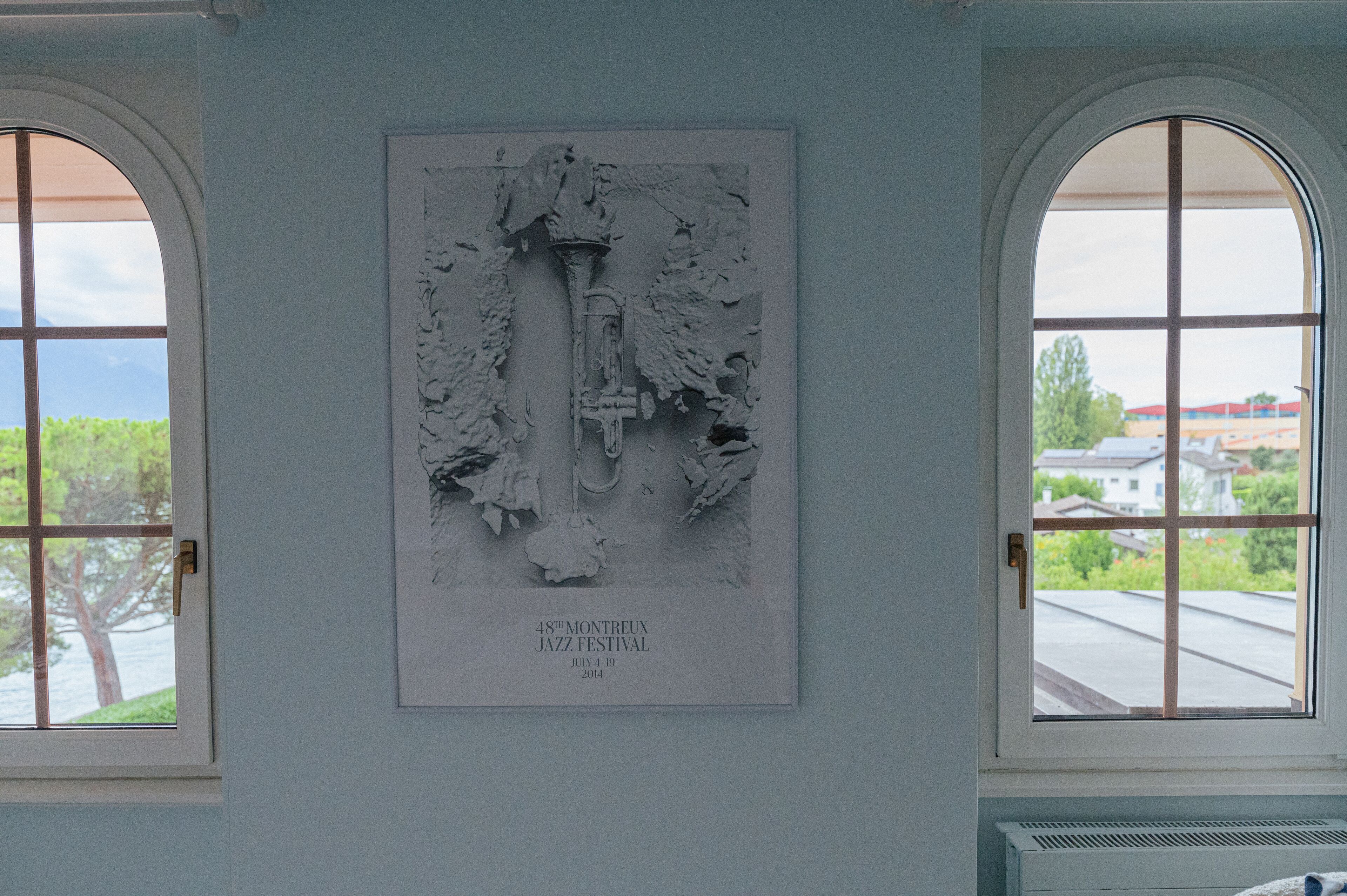 A wall with a relief sculpture and two arched windows.