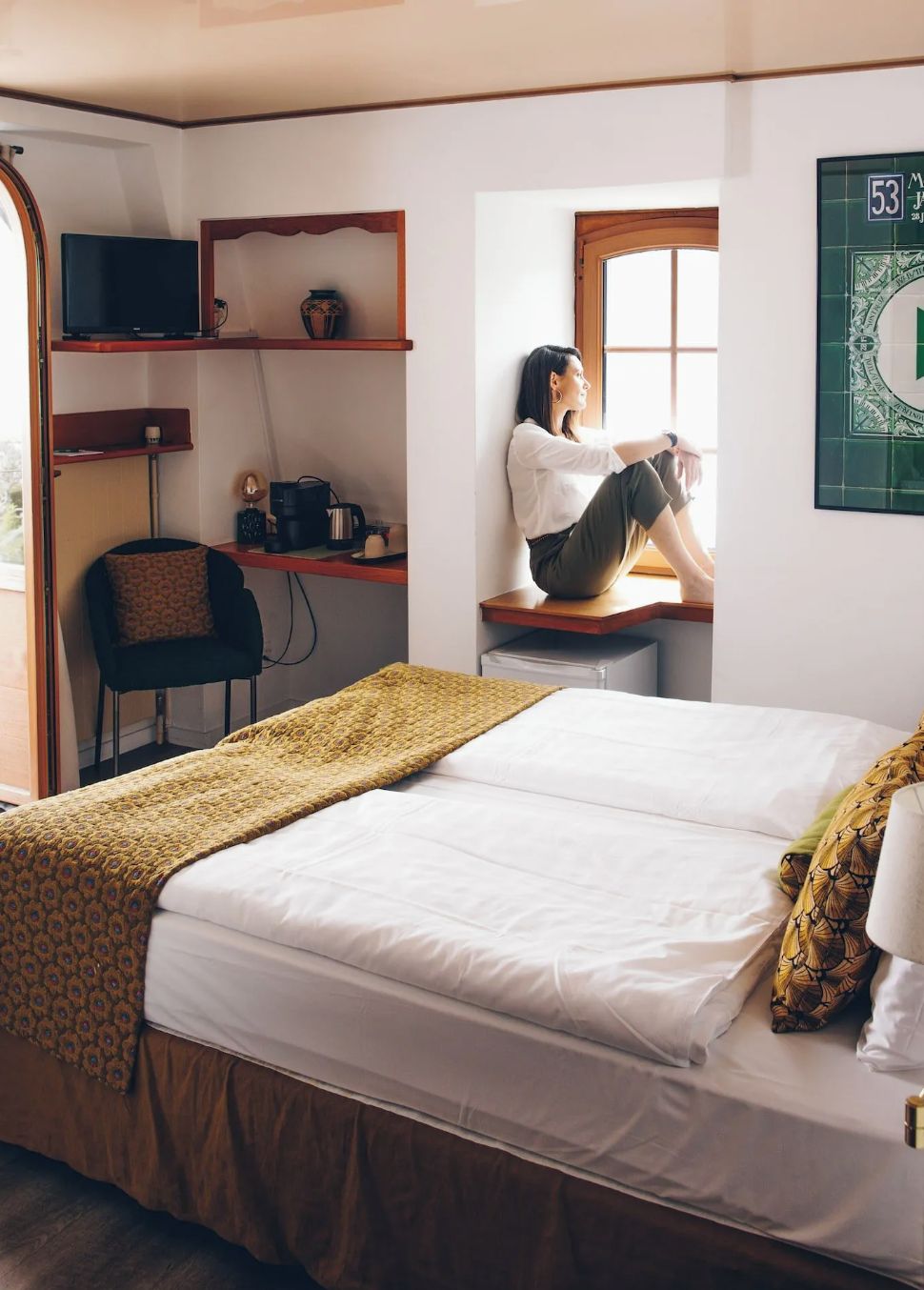 A compact bedroom with a bed, a desk, and a chair.