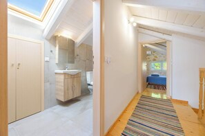 Une salle de bain moderne avec un puits de lumière, des meubles en bois et un lavabo.