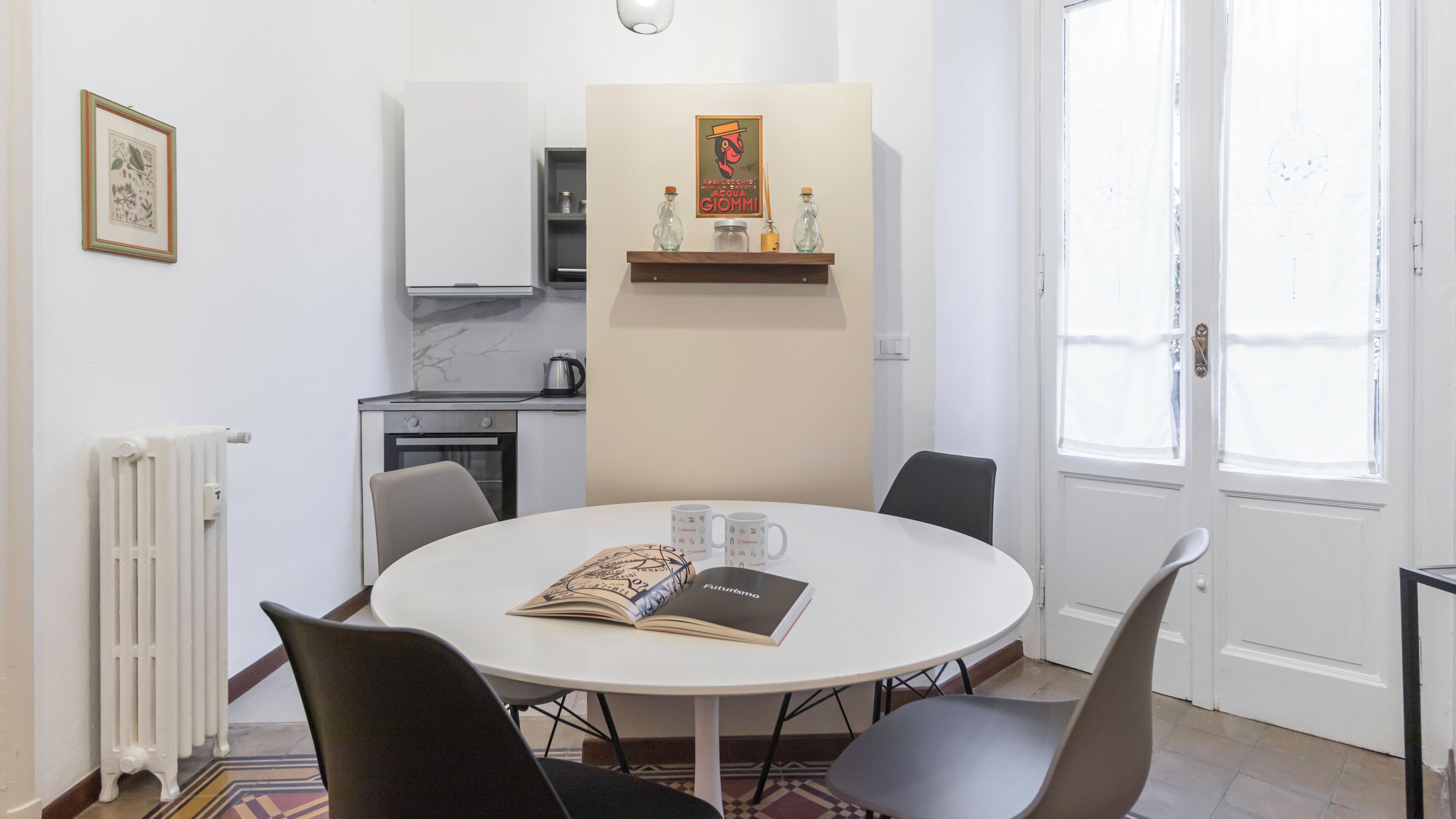 Un coin repas avec une table ronde, des chaises, un livre et une machine à café.