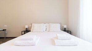 A hotel room with a large bed, two nightstands, and two lamps. - Italianway - Ozieri 7 (Milan)