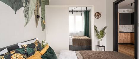 Un dormitorio moderno con una cama, un sofá y vista a una cocina.