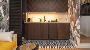 A modern kitchen with dark wooden cabinets, a marble countertop, and a geometric patterned backsplash. - RentPlanet - Apartament Długa (Wroclaw)