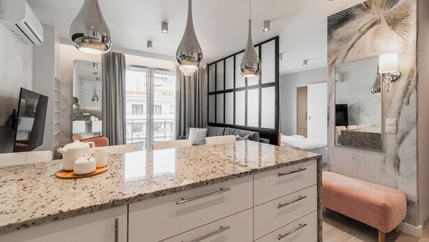 A modern bathroom with a granite countertop, a large mirror, and a bench. - RentPlanet - Apartament Długa (Wroclaw)