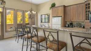 Eine Küche mit Barbereich, Holzausstattung und einem großen Fenster mit Herbstlaub.