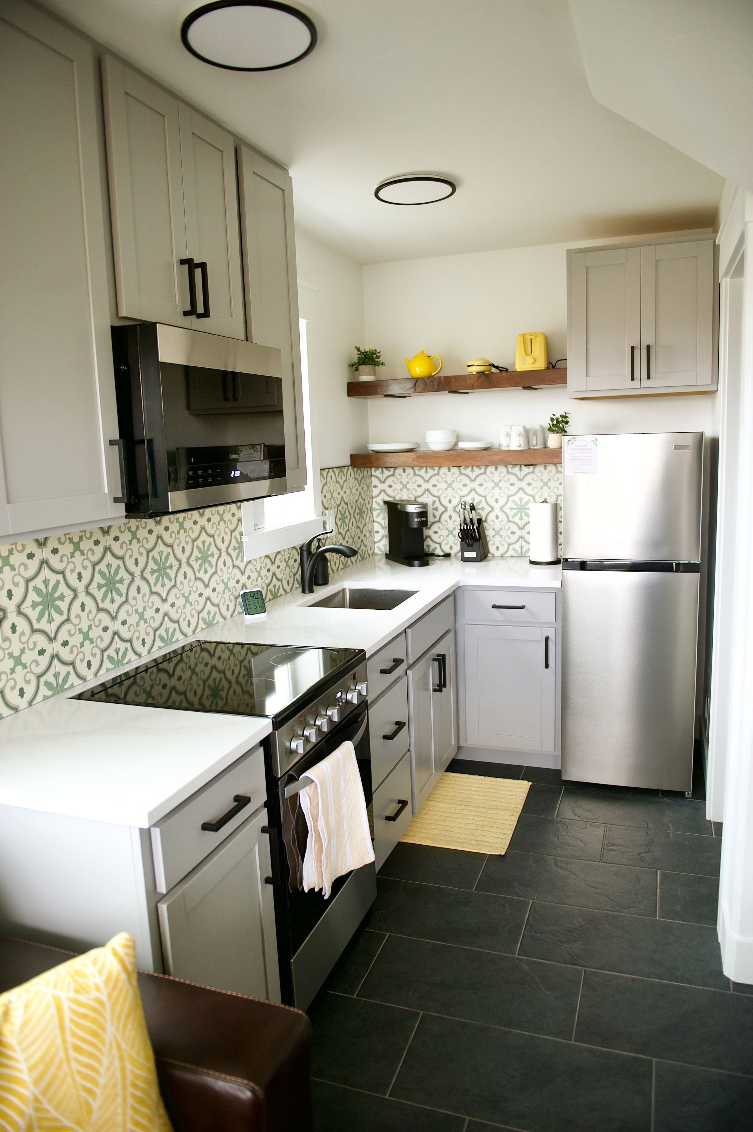 A compact kitchen with a stove, oven, microwave, and refrigerator.